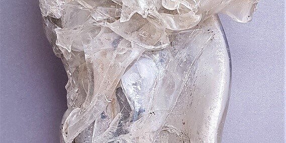 Klumpen aus geschmolzenem Glas vor hellblauem Hintergrund vom Marienhof.